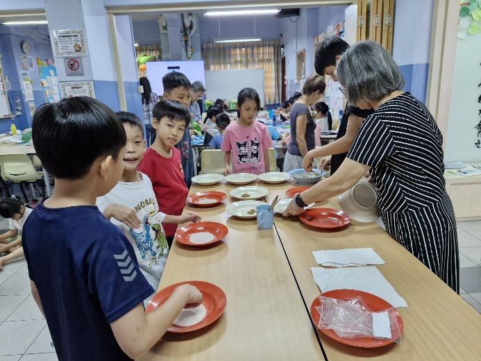 A group of children at a table with plates

Description automatically generated