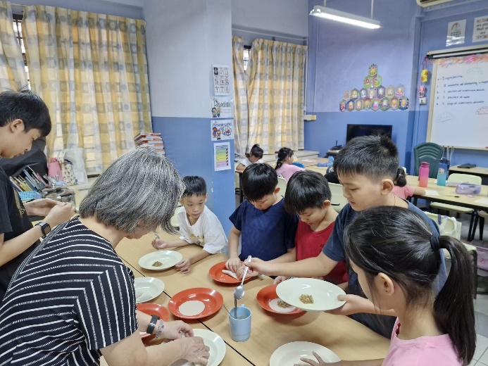 A group of children eating at a table

Description automatically generated