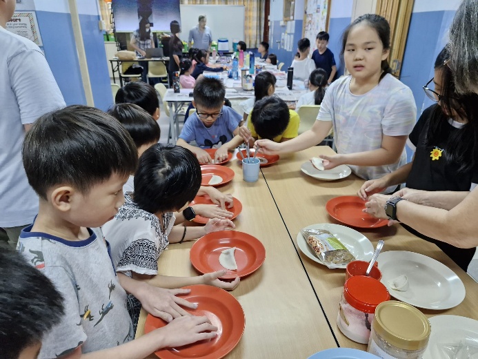 A group of children eating at a table

Description automatically generated