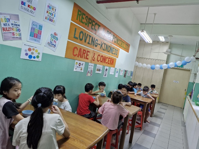 A group of children eating in a classroom

Description automatically generated