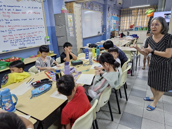 A group of children sitting at desks in a classroom

Description automatically generated