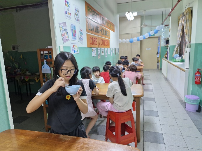 A group of people sitting at tables in a classroom

Description automatically generated